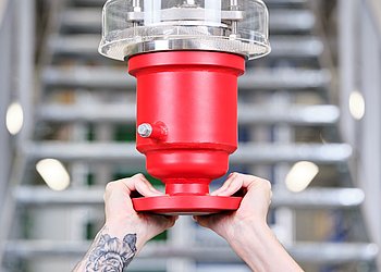Zwei Hände halten Flammschutzarmatur vor Treppe